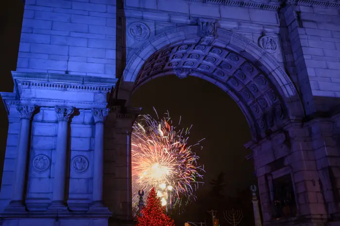 Fireworks viewed through a massive arch in Brooklyn.